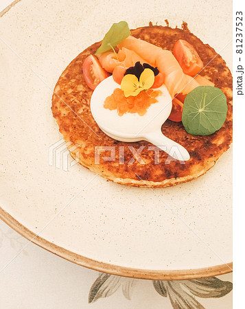 Potato fritter pancake with red caviar, salmon and sour cream in luxury restaurant outdoors in summer 81237523