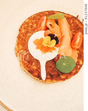 Potato fritter pancake with red caviar, salmon and sour cream in luxury restaurant outdoors in summer 81237606