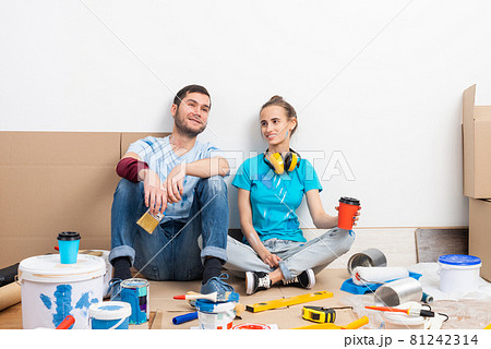 Happy boy and girl drinking coffee on floor. 81242314