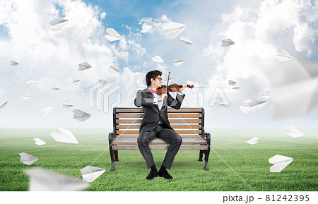 Young businessman plays the violin Young businessman plays the violin 81242395