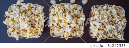 Popcorn in red and white container on a dark background BANNER, LONG FORMAT 81242583