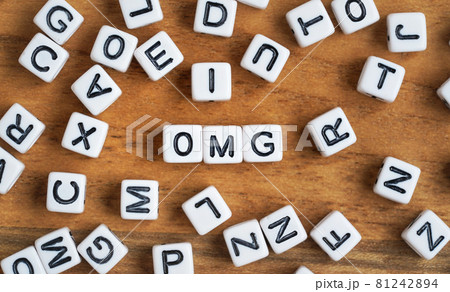 Small white and black bead cubes on wooden board, letters in middle spell OMG Small white and black bead cubes on wooden board, letters in middle spell OMG 81242894