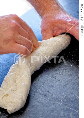 Close-up view of professional baker preparing bread dough in a kitchen 81245520