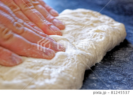Close-up view of professional baker preparing bread dough in a kitchen Close-up view of professional baker preparing bread dough in a kitchen 81245537