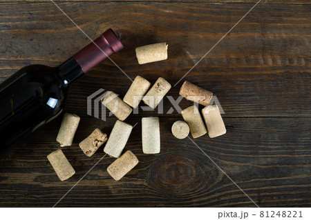 Glass wine bottle with corks and corkscrew on wooden table background. Glass wine bottle with corks and corkscrew on wooden table background. 81248221