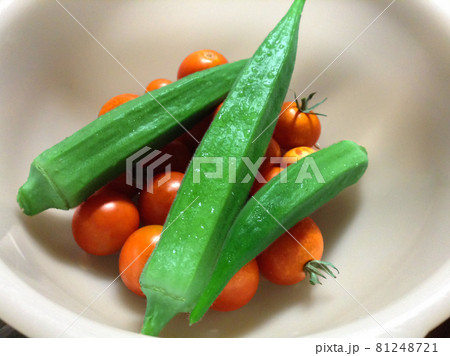 夏野菜のオクラとミニトマト 白いボールの中にたくさん入れられた新鮮な野菜の写真素材