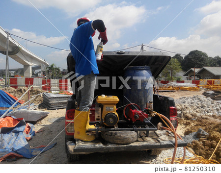 JOHOR, MALAYSIA -AUGUST 21, 2015: Construction workers mixing the anti termite chemical using drums at the construction site.  81250310
