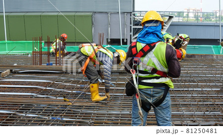 MALACCA, MALAYSIA -JULY 23, 2016: Construction workers wearing safety harness belt at other safety gear during working at the construction site area. MALACCA, MALAYSIA -JULY 23, 2016: Construction workers wearing safety harness belt at other safety gear during working at the construction site area. 81250481