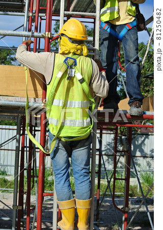 MALACCA, MALAYSIA -JULY 23, 2016: Construction workers wearing safety harness belt at other safety gear during working at the construction site area.   81250482
