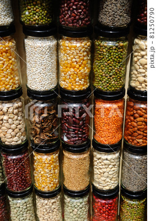 PUTRAJAYA, MALAYSIA -MAY 30, 2016: Seeds, nuts and grains in bottles and stacked against a wall. PUTRAJAYA, MALAYSIA -MAY 30, 2016: Seeds, nuts and grains in bottles and stacked against a wall. 81250790