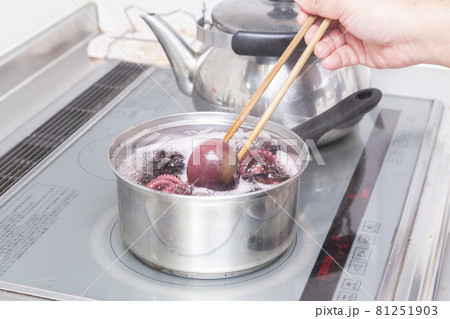 タコを茹でる男性の手元 81251903