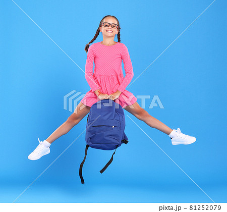 Energetic happy schoolgirl in eyewear with funny surprised facial expression jumping up in air Energetic happy schoolgirl in eyewear with funny surprised facial expression jumping up in air 81252079