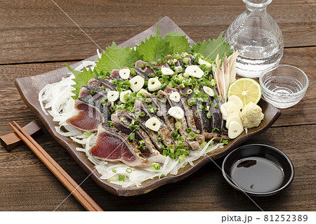 ネギとニンニクをかけた鰹のたたきと日本酒 81252389