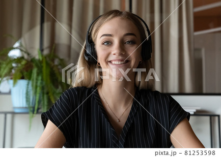 Portrait of smiling woman in earphones talk on video call 81253598