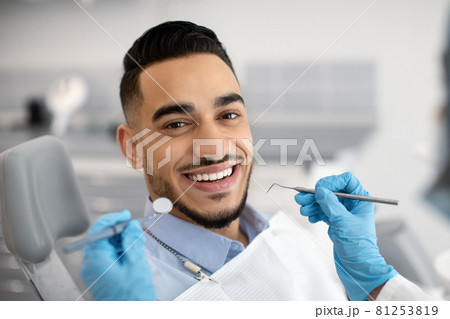 Portrait Of Happy Arab Man Sitting At Dentist Chair In Modern Clinic 81253819