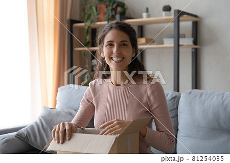 Woman holding parcel box feels pleased with ordered goods Woman holding parcel box feels pleased with ordered goods 81254035