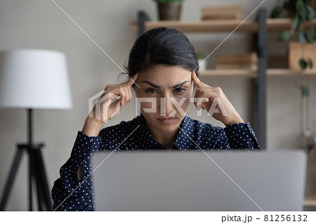 Pensive Indian woman look at laptop thinking Pensive Indian woman look at laptop thinking 81256132