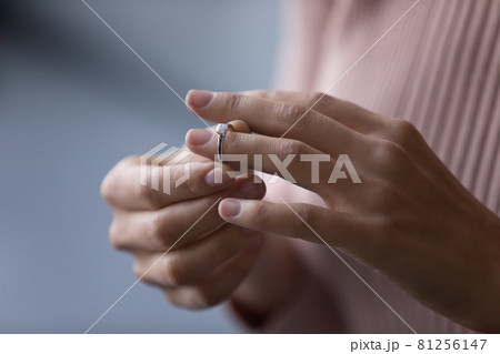Young woman takes off wedding ring, close up view 81256147