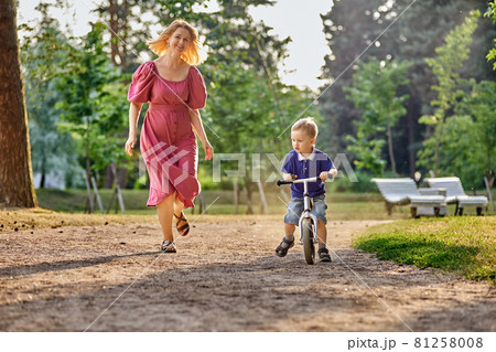 Mother and boy 3 years old on bicycle in park. Mother and boy 3 years old on bicycle in park. 81258008