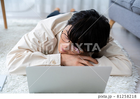 寝そべってノートパソコンを使いながら眼鏡をかけたまま寝てしまう男性 81258218
