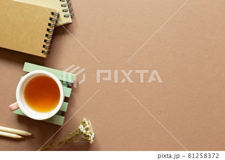 Notebook, colored pencil, dry flower, tea cup on brown background. flat lay, top view, copy space. Work and study place Notebook, colored pencil, dry flower, tea cup on brown background. flat lay, top view, copy space. Work and study place 81258372