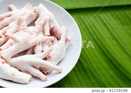 Raw chicken feet in white plate on banana leaf Raw chicken feet in white plate on banana leaf 81259106