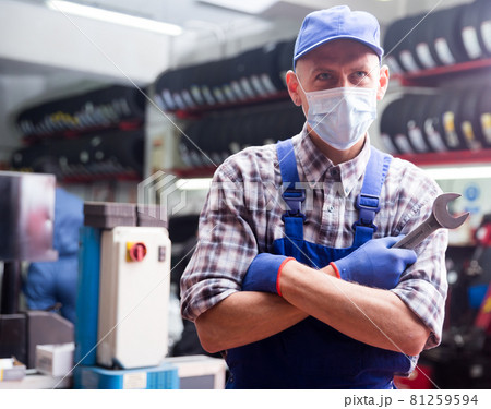 Portrait of mechanician in mask posing at auto service Portrait of mechanician in mask posing at auto service 81259594