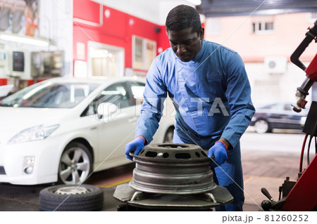 African american mechanic fixes car rims in car service African american mechanic fixes car rims in car service 81260252