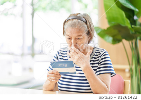 銀行の通帳を見て驚く高齢者 銀行の通帳を見て驚く高齢者 81261422