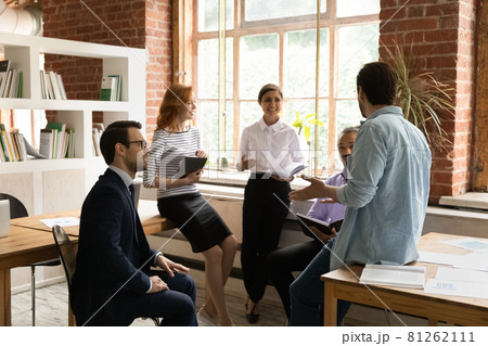 Five employees gather in morning briefing led by Caucasian executive Five employees gather in morning briefing led by Caucasian executive 81262111