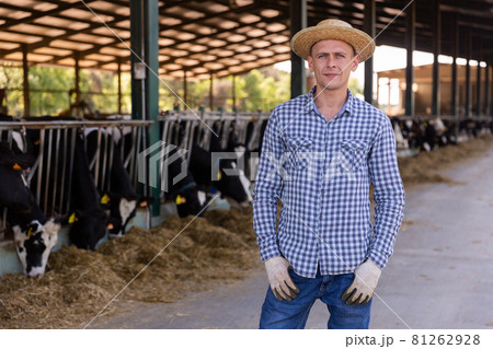 Male farmer posing at cowshed on farm 81262928