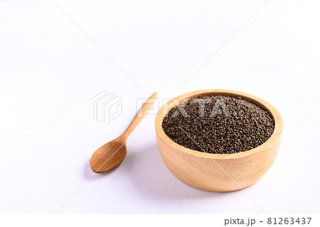 Perilla seeds in a wooden bowl and spoon on white background 81263437