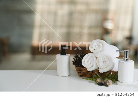 White towels and shampoo bottles on white table for relax spa massage and body treatment. White towels and shampoo bottles on white table for relax spa massage and body treatment. 81264554