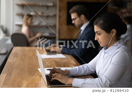 Indian woman working on computer sit in coworking space 81266410