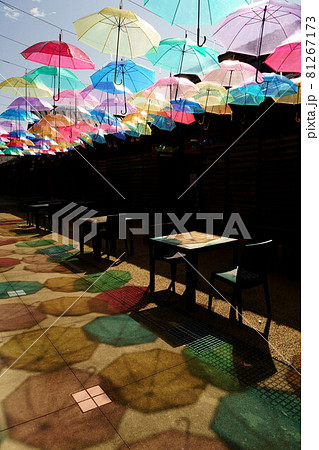 氷見一番街のテラスで青空を彩るたくさんのビニール傘と鮮やかな傘の影縦構図 81267173