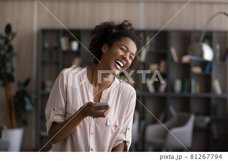 Excited African American woman overjoyed with cellphone news 81267794