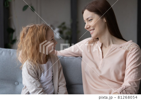 Smiling young mother and teen daughter relax at home Smiling young mother and teen daughter relax at home 81268054