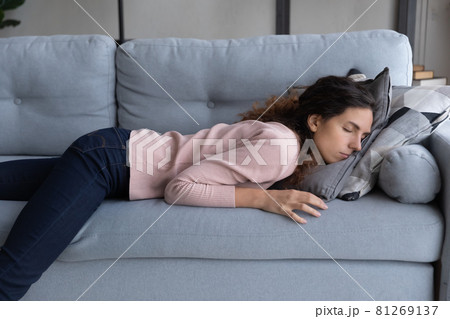 Exhausted woman lying sleeping on sofa after sleepless night 81269137