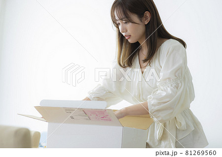 荷物の箱を開ける女性　 81269560
