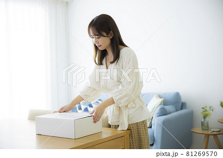 荷物の箱を開ける女性 荷物の箱を開ける女性 81269570