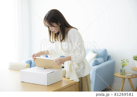 荷物の箱を開ける女性 荷物の箱を開ける女性 81269581