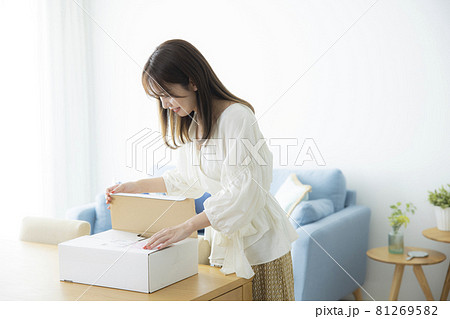 荷物の箱を開ける女性　 81269582