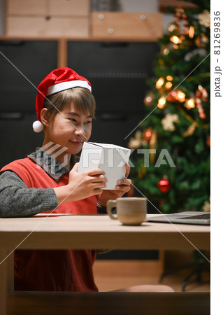 Portrait of young woman during quarantine long distance celebration with her friend over laptop at home. Portrait of young woman during quarantine long distance celebration with her friend over laptop at home. 81269836