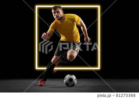 Abstract desing, concept of sport, action, motion in sport. Young Caucasian football, soccer player in neon light on black background Abstract desing, concept of sport, action, motion in sport. Young Caucasian football, soccer player in neon light on black background 81273368
