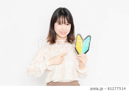 初心者マークを持って、立っている女性 初心者マークを持って、立っている女性 81277514