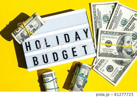 Lightbox board with word HOLIDAY BUDGET on yellow background around dollar banknotes. Money, Business, finance, investment, saving Lightbox board with word HOLIDAY BUDGET on yellow background around dollar banknotes. Money, Business, finance, investment, saving 81277725