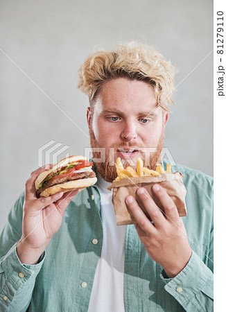 Young man eating fast food 81279110