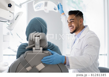 Young Arab Dentist Doctor Having Check Up With Islamic Female Patient 81281385