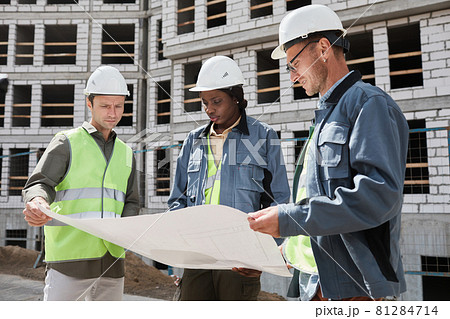 Construction Workers Holding Blueprint 81284714