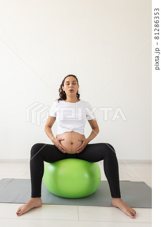 beautiful young pregnant woman doing exercise at home on fitball 81286353
